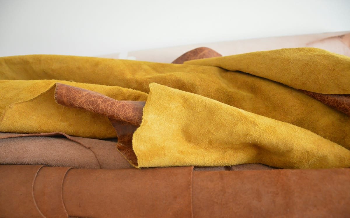 Rolled hides of mustard suede and brown leather in the workshop