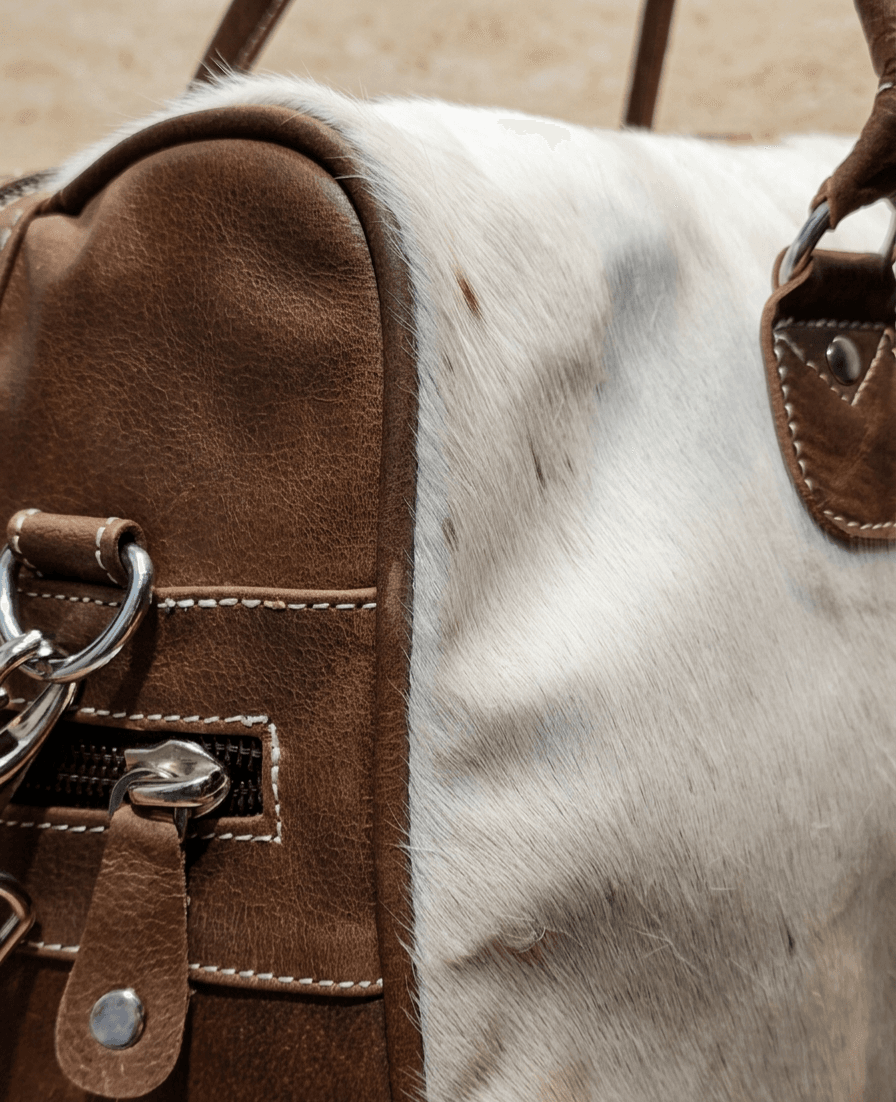 Hair-on cowhide leather duffel bag, close-up of the hardware and stitching